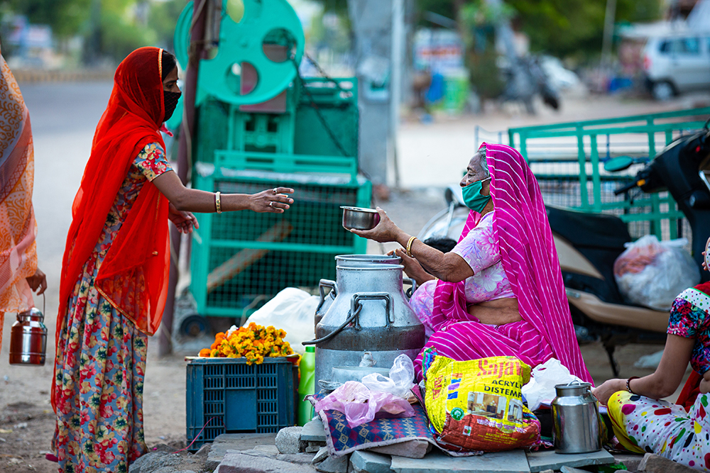 Roadside kirana vendor and customer wearing face masks in Rajasthan.